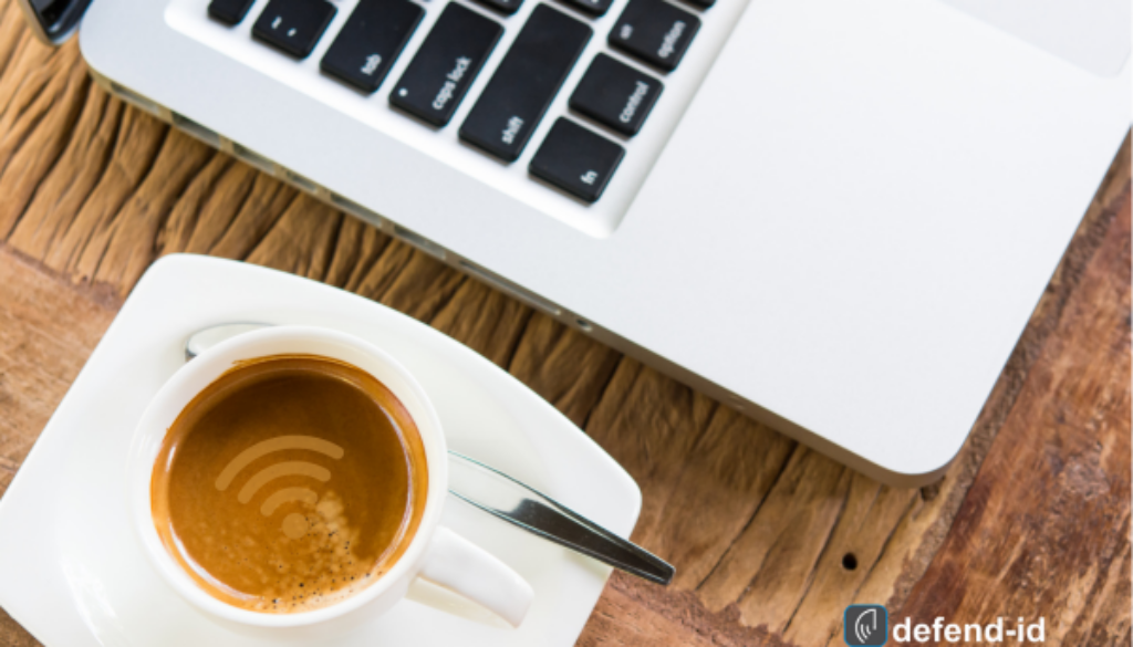 Laptop with a WiFi symbol on a coffee cup on a wooden table, indicating public WiFi use while enjoying a beverage