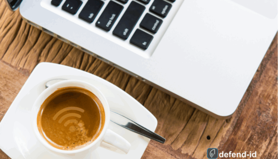 Laptop with a WiFi symbol on a coffee cup on a wooden table, indicating public WiFi use while enjoying a beverage