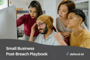 Small business team collaborating on a post-breach playbook at a computer with defend-id branding
